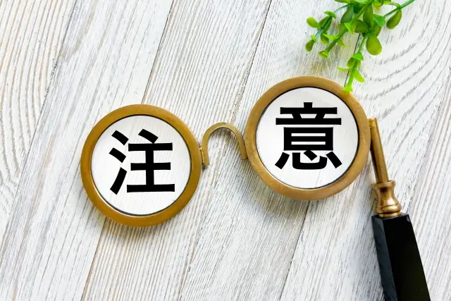 注意と書かれたブロックとメガネ