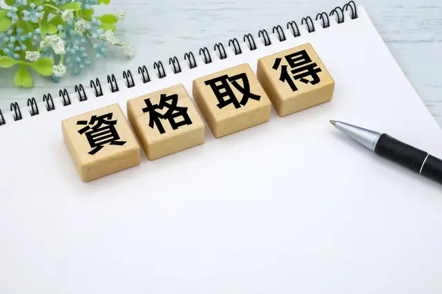 資格取得と書かれたブロックとノート