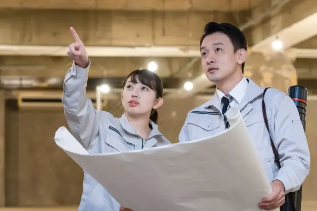 設計図を見て話しあう男女の施工管理技士