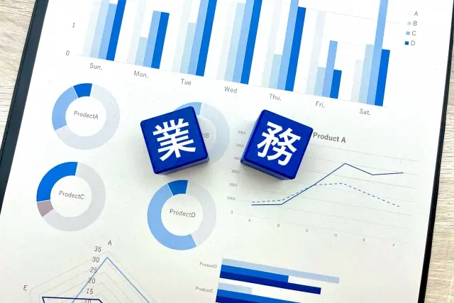 業務と書かれたブロックとグラフを印刷した紙