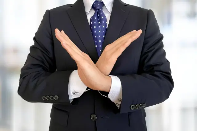 手でバツを作る男性